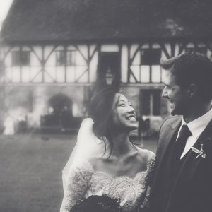 Bride and groom outside Medieval style building in gardens