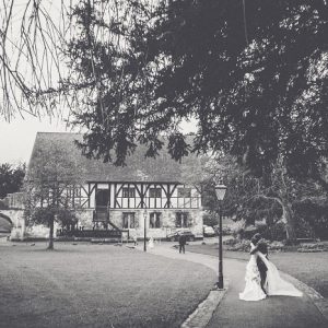 Wedding couple with Medieval style building in gardens